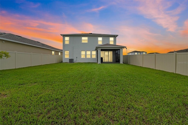 32136 Conchshell Sail St, Wesley Chapel, FL 33545 - back of property at dusk with central air condition unit, stucco siding, and a sunroom