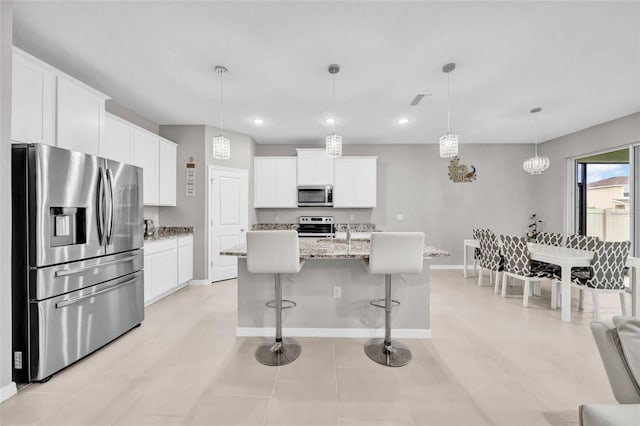 32136 Conchshell Sail St, Wesley Chapel, FL 33545 - kitchen with appliances with stainless steel finishes, white cabinetry, a breakfast bar area, baseboards, and recessed lighting