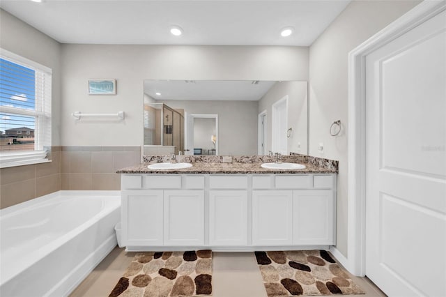 32136 Conchshell Sail St, Wesley Chapel, FL 33545 - bathroom with double vanity, a stall shower, a bath, and recessed lighting