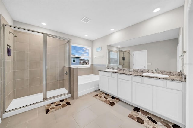32136 Conchshell Sail St, Wesley Chapel, FL 33545 - bathroom with a bath, a stall shower, double vanity, tile patterned flooring, and recessed lighting