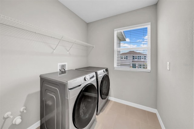 32136 Conchshell Sail St, Wesley Chapel, FL 33545 - laundry room with washer and dryer, baseboards, and light tile patterned flooring