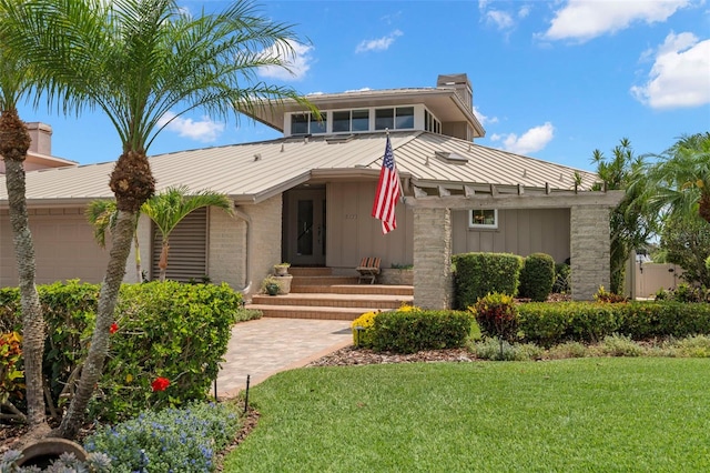 5782 Westshore Dr, New Port Richey, FL 34652 - mid-century inspired home featuring board and batten siding, a chimney, a front lawn, a standing seam roof, and metal roof