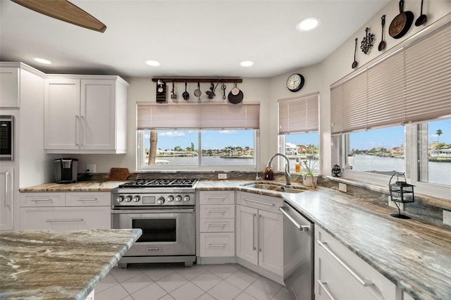 5782 Westshore Dr, New Port Richey, FL 34652 - kitchen featuring appliances with stainless steel finishes, a sink, recessed lighting, white cabinets, and light stone counters