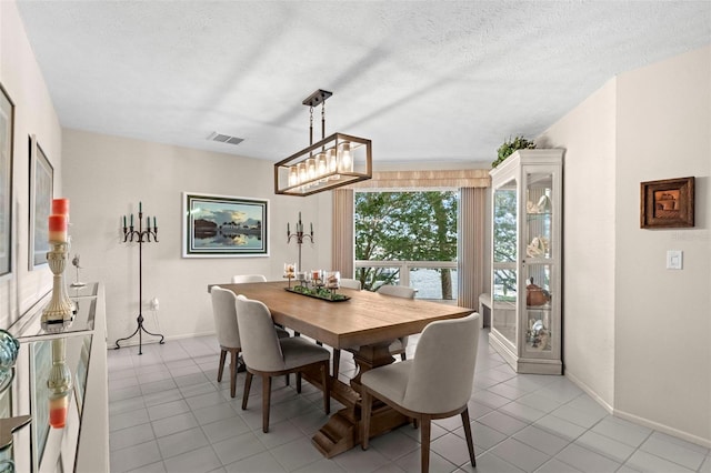 5782 Westshore Dr, New Port Richey, FL 34652 - dining space featuring light tile patterned floors, a chandelier, and baseboards