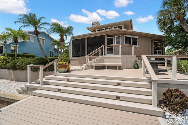 5782 Westshore Dr, New Port Richey, FL 34652 - rear view of property with stairway, a sunroom, and a wooden deck