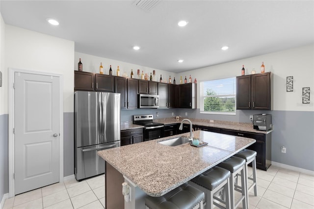 12481 Aston Dr, Hudson, FL 34669 - kitchen with stainless steel appliances, a kitchen breakfast bar, dark brown cabinetry, a sink, and recessed lighting