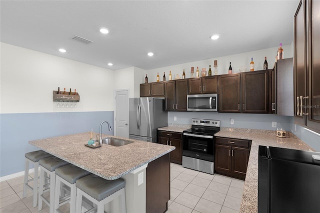 12481 Aston Dr, Hudson, FL 34669 - kitchen with stainless steel appliances, a sink, light tile patterned floors, a kitchen breakfast bar, and recessed lighting