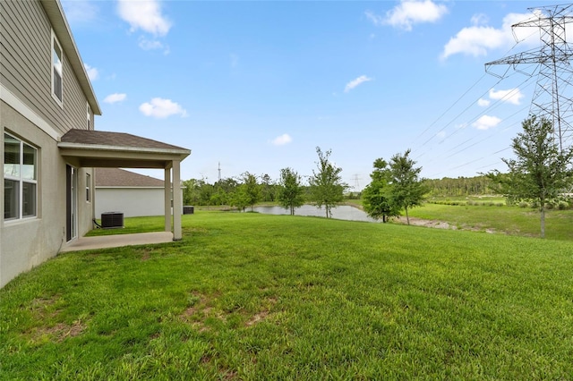 12481 Aston Dr, Hudson, FL 34669 - view of green lawn featuring central air condition unit, a water view, and a patio area