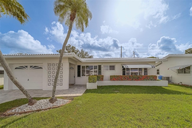 10005 41st St N, Pinellas Park, FL 33782 - view of front of house with an attached garage, stucco siding, a front lawn, central AC, and a tile roof