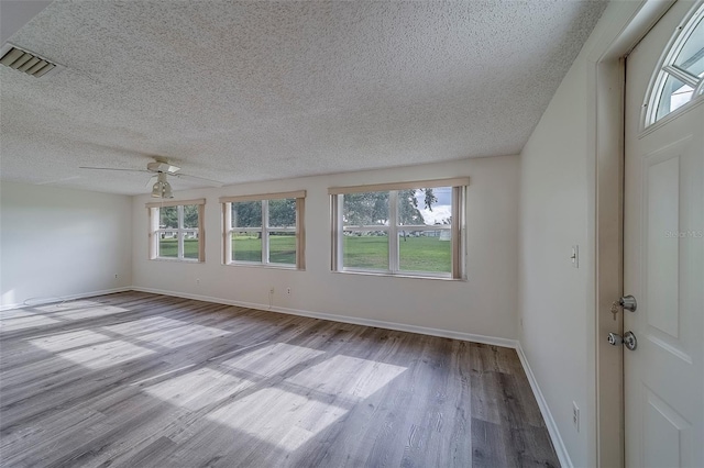 10005 41st St N, Pinellas Park, FL 33782 - empty room featuring wood finished floors, healthy amount of natural light, ceiling fan, and a textured ceiling