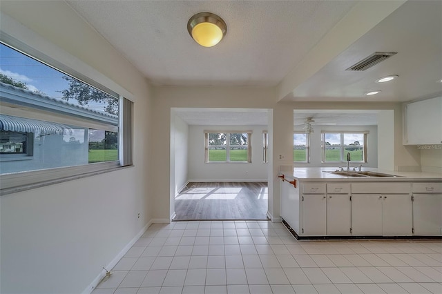 10005 41st St N, Pinellas Park, FL 33782 - kitchen featuring a sink, light countertops, white cabinets, baseboards, and light tile patterned floors