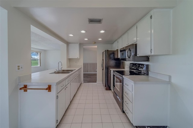 10005 41st St N, Pinellas Park, FL 33782 - kitchen with black appliances, a sink, light countertops, a peninsula, and white cabinetry