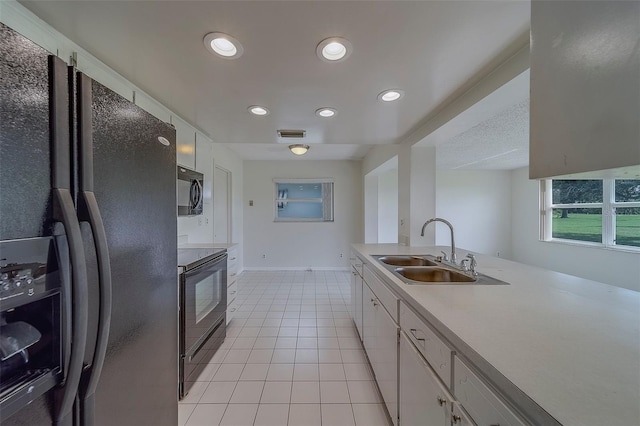 10005 41st St N, Pinellas Park, FL 33782 - kitchen featuring black appliances, a sink, white cabinets, light tile patterned floors, and recessed lighting