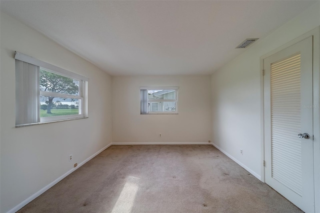 10005 41st St N, Pinellas Park, FL 33782 - unfurnished bedroom featuring multiple windows, carpet, and baseboards