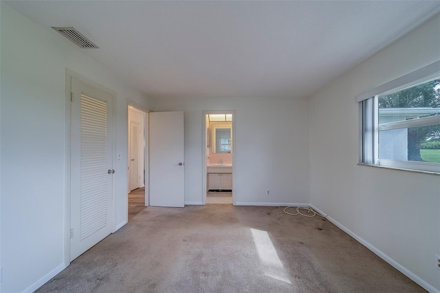 10005 41st St N, Pinellas Park, FL 33782 - unfurnished bedroom with carpet flooring, baseboards, connected bathroom, and a closet