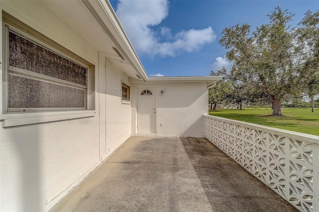 10005 41st St N, Pinellas Park, FL 33782 - doorway to property featuring stucco siding and a yard