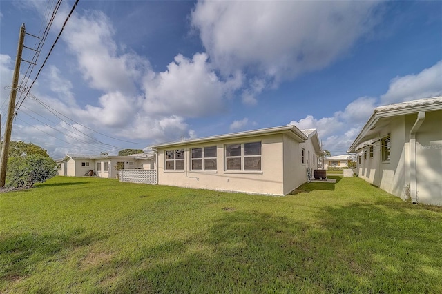 10005 41st St N, Pinellas Park, FL 33782 - rear view of house featuring stucco siding, central AC, and a lawn