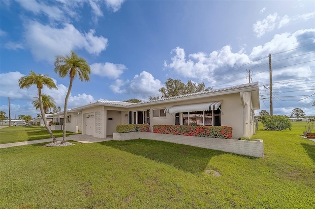 10005 41st St N, Pinellas Park, FL 33782 - rear view of property with stucco siding, an attached garage, and a yard