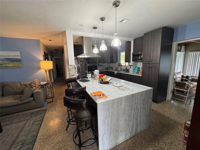 2160 NE 53rd St, Fort Lauderdale, FL 33308 - kitchen featuring extractor fan, appliances with stainless steel finishes, a breakfast bar, light countertops, and open floor plan