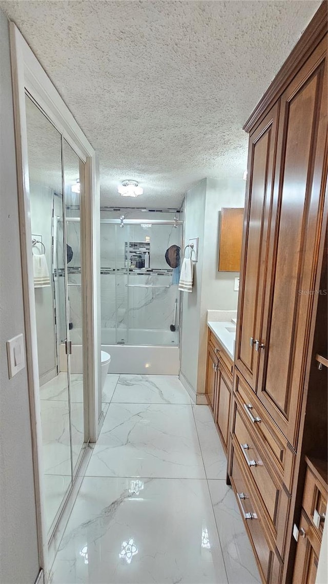 6424 Thicket Trl, New Port Richey, FL 34653 - full bathroom featuring marble look tile flooring, vanity, toilet, a textured ceiling, and enclosed tub / shower combo