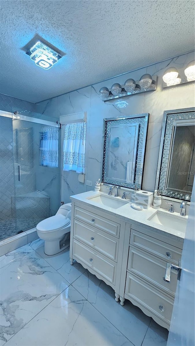 6424 Thicket Trl, New Port Richey, FL 34653 - bathroom with double vanity, marble finish floors, a shower stall, toilet, and a textured ceiling