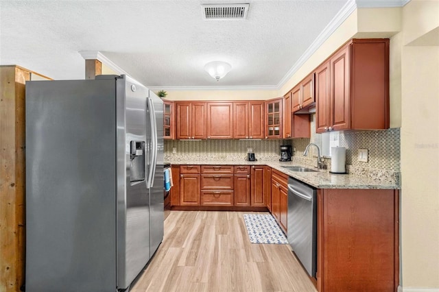 10339 111th St, Largo, FL 33778 - kitchen featuring stainless steel appliances, ornamental molding, light wood-type flooring, light stone counters, and backsplash