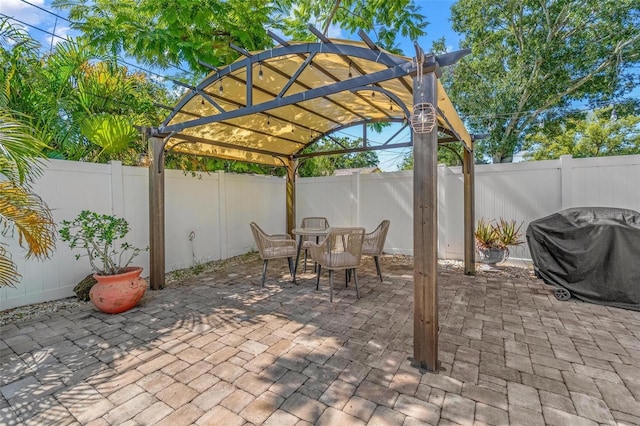 10339 111th St, Largo, FL 33778 - fenced backyard with a grill, a pergola, outdoor dining space, and a patio area