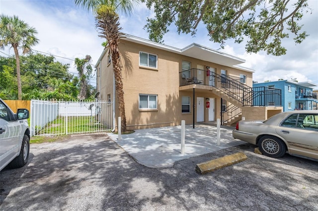 1771 Russell St S, Saint Petersburg, FL 33712 - view of front facade featuring stucco siding, uncovered parking, and stairway