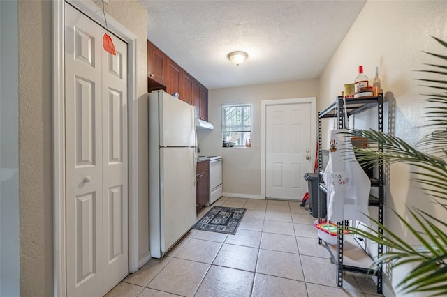1771 Russell St S, Saint Petersburg, FL 33712 - kitchen featuring white appliances, under cabinet range hood, a textured ceiling, light tile patterned flooring, and brown cabinets
