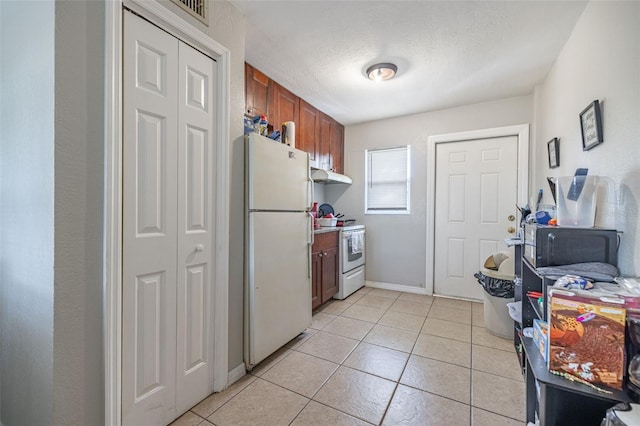1771 Russell St S, Saint Petersburg, FL 33712 - kitchen featuring white appliances, under cabinet range hood, light tile patterned floors, brown cabinetry, and a textured ceiling