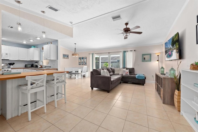 3905 31st Ave W, Bradenton, FL 34205 - living area with a ceiling fan, a textured ceiling, ornamental molding, and light tile patterned floors