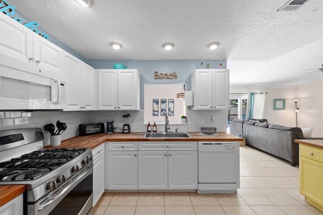 3905 31st Ave W, Bradenton, FL 34205 - kitchen featuring white appliances, wooden counters, backsplash, open floor plan, and light tile patterned floors