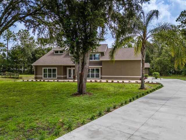 4044 Red Fox Ct, Wesley Chapel, FL 33543 - view of front of property featuring stucco siding, a front yard, concrete driveway, and roof with shingles