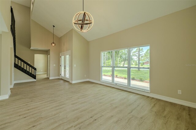 4044 Red Fox Ct, Wesley Chapel, FL 33543 - unfurnished living room with wood finished floors, high vaulted ceiling, stairway, and baseboards