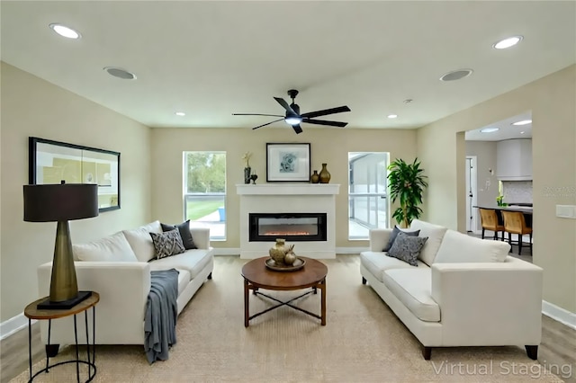 4044 Red Fox Ct, Wesley Chapel, FL 33543 - living area featuring baseboards, a glass covered fireplace, ceiling fan, recessed lighting, and light wood-type flooring