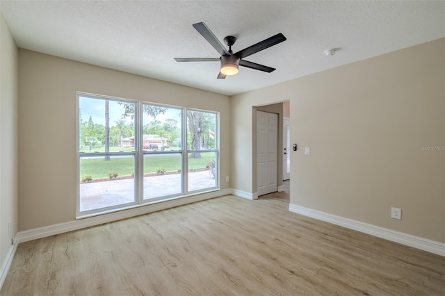 4044 Red Fox Ct, Wesley Chapel, FL 33543 - spare room featuring light wood-style floors, baseboards, a ceiling fan, a smoke detector, and a textured ceiling