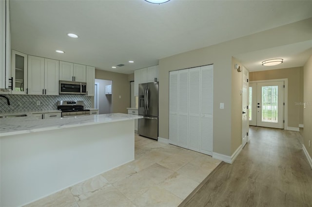 4044 Red Fox Ct, Wesley Chapel, FL 33543 - kitchen featuring stainless steel appliances, a sink, light stone countertops, a peninsula, and recessed lighting