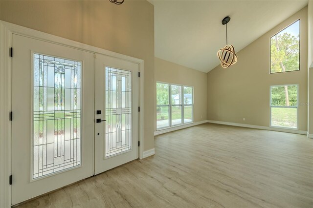 4044 Red Fox Ct, Wesley Chapel, FL 33543 - foyer entrance featuring high vaulted ceiling, baseboards, light wood finished floors, and a chandelier