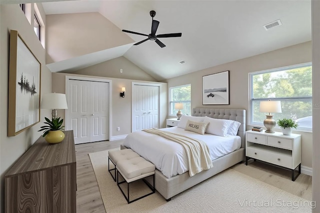 4044 Red Fox Ct, Wesley Chapel, FL 33543 - bedroom with multiple closets, vaulted ceiling, light wood-style floors, a ceiling fan, and baseboards