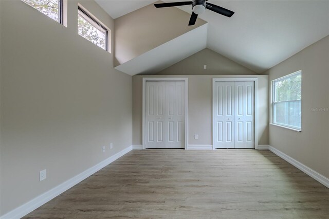 4044 Red Fox Ct, Wesley Chapel, FL 33543 - unfurnished bedroom featuring multiple closets, wood finished floors, lofted ceiling, baseboards, and ceiling fan