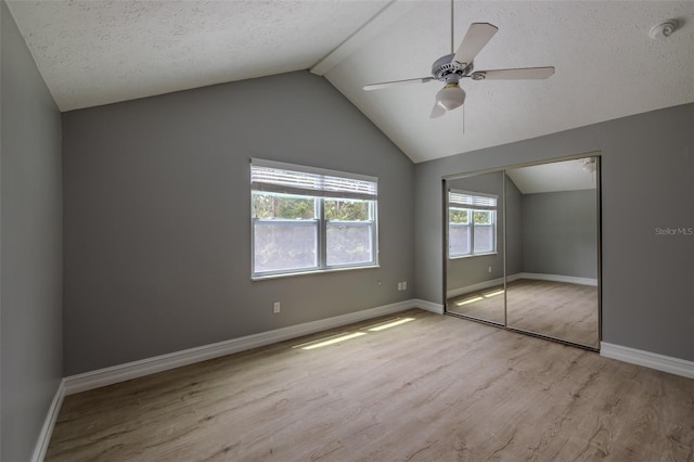 4044 Red Fox Ct, Wesley Chapel, FL 33543 - unfurnished bedroom featuring wood finished floors, lofted ceiling, baseboards, a closet, and a textured ceiling