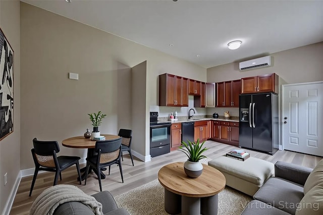 4044 Red Fox Ct, Wesley Chapel, FL 33543 - kitchen featuring black appliances, a wall mounted AC, light wood-style floors, and light countertops