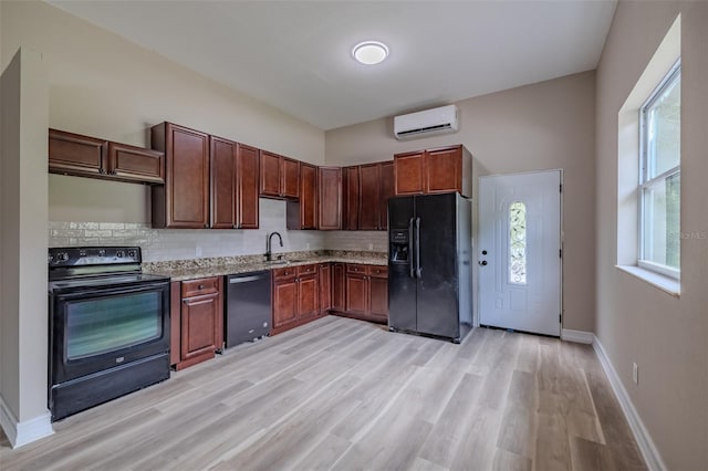 4044 Red Fox Ct, Wesley Chapel, FL 33543 - kitchen with black appliances, an AC wall unit, light wood-type flooring, tasteful backsplash, and baseboards