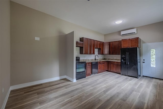 4044 Red Fox Ct, Wesley Chapel, FL 33543 - kitchen with black appliances, a wall unit AC, baseboards, and light wood finished floors