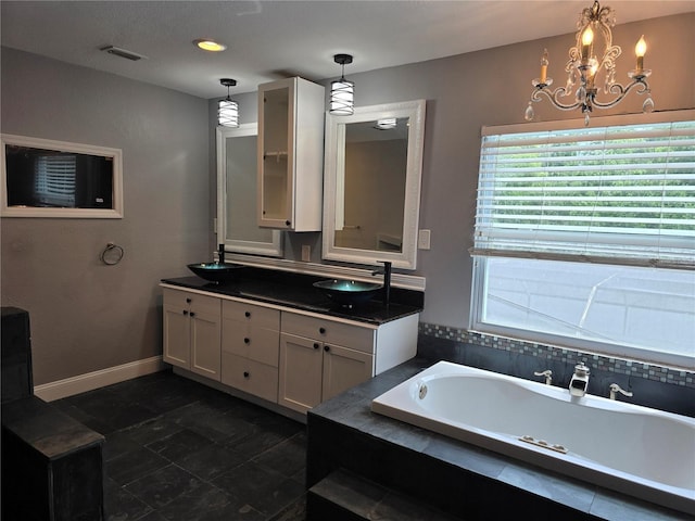4044 Red Fox Ct, Wesley Chapel, FL 33543 - bathroom with a garden tub, double vanity, a chandelier, and baseboards