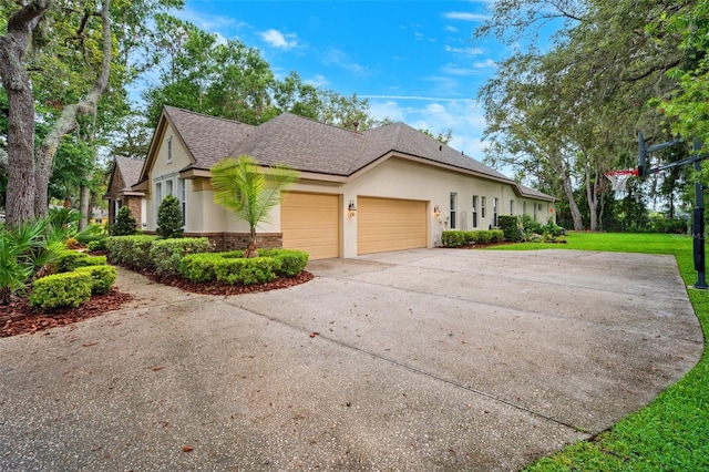 17802 Mission Oak Dr, Lithia, FL 33547 - view of property exterior featuring an attached garage, stucco siding, driveway, a shingled roof, and a yard
