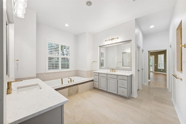 17802 Mission Oak Dr, Lithia, FL 33547 - bathroom featuring two vanities, healthy amount of natural light, a bath, tile patterned flooring, and recessed lighting