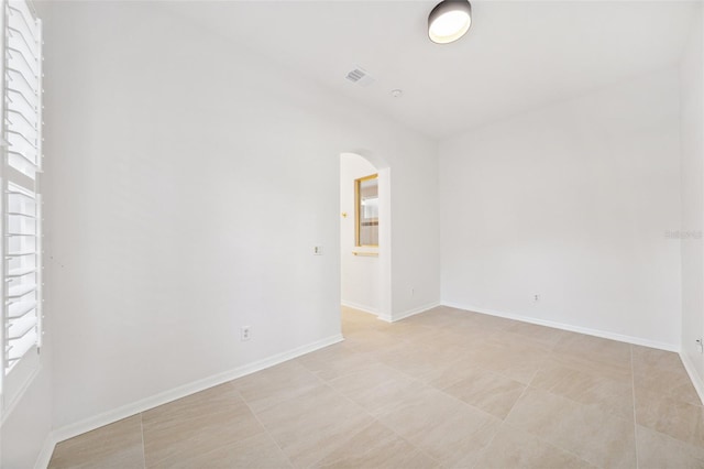 17802 Mission Oak Dr, Lithia, FL 33547 - spare room with arched walkways, baseboards, and light tile patterned flooring
