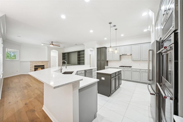 17802 Mission Oak Dr, Lithia, FL 33547 - kitchen with a spacious island, a sink, ornamental molding, ceiling fan, and a fireplace