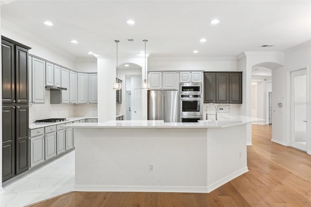 17802 Mission Oak Dr, Lithia, FL 33547 - kitchen with arched walkways, stainless steel appliances, backsplash, light countertops, and ornamental molding